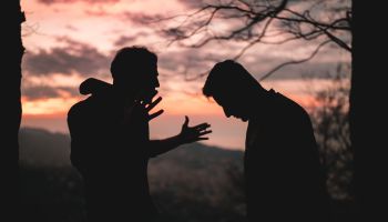 Silhouette of two men, one with arms raised and the other with head hanging down, to illustrate the article 