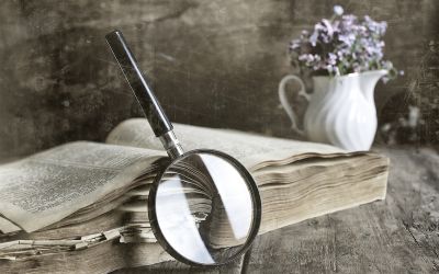 Photo of a magnifying glass leaning against a Bible to illustrate the article The Greatest Mystery of the Bible