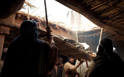 Photo illustration of a man being lowered through a roof to illustrate one of Jesus' healings, for the article What Can We Learn From Jesus’ Early Healings?