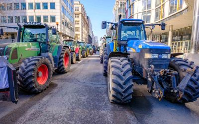 Photo of tractors on a city street as part of a protest, to illustrate the article, Why Farmers Are Protesting Around the World